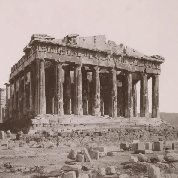 Sepia photo from the 1880s of the Parthenon on the Acropolis in Athens, with fallen stone blocks in the foreground