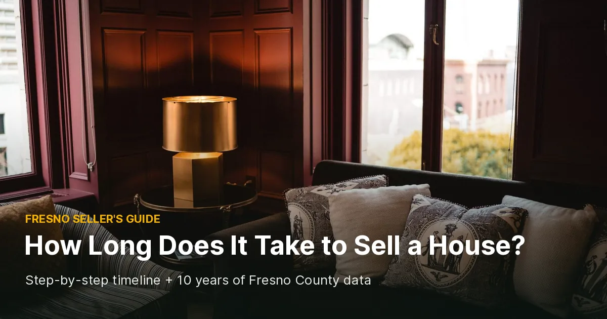 Warm sitting room with a brass table lamp, patterned throw pillows on a dark sofa and tall windows, cover photo for a guide to how long it takes to sell a house